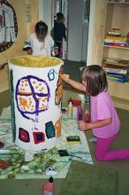 Kinder beim Basteln an Turm aus Papier